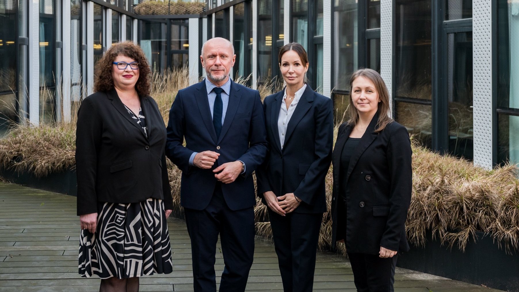 The picture shows City of Poznań officials standing together. From the left you can see: Agnieszka Susicka, Bartosz Guss, Katja Lożina and Dominika Błaszyk. Behind them there is visible grass and office building.