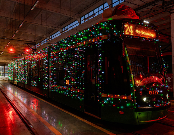 Na zdjęciu ozdobiony światełkami tramwaj, stojący w zajezdni