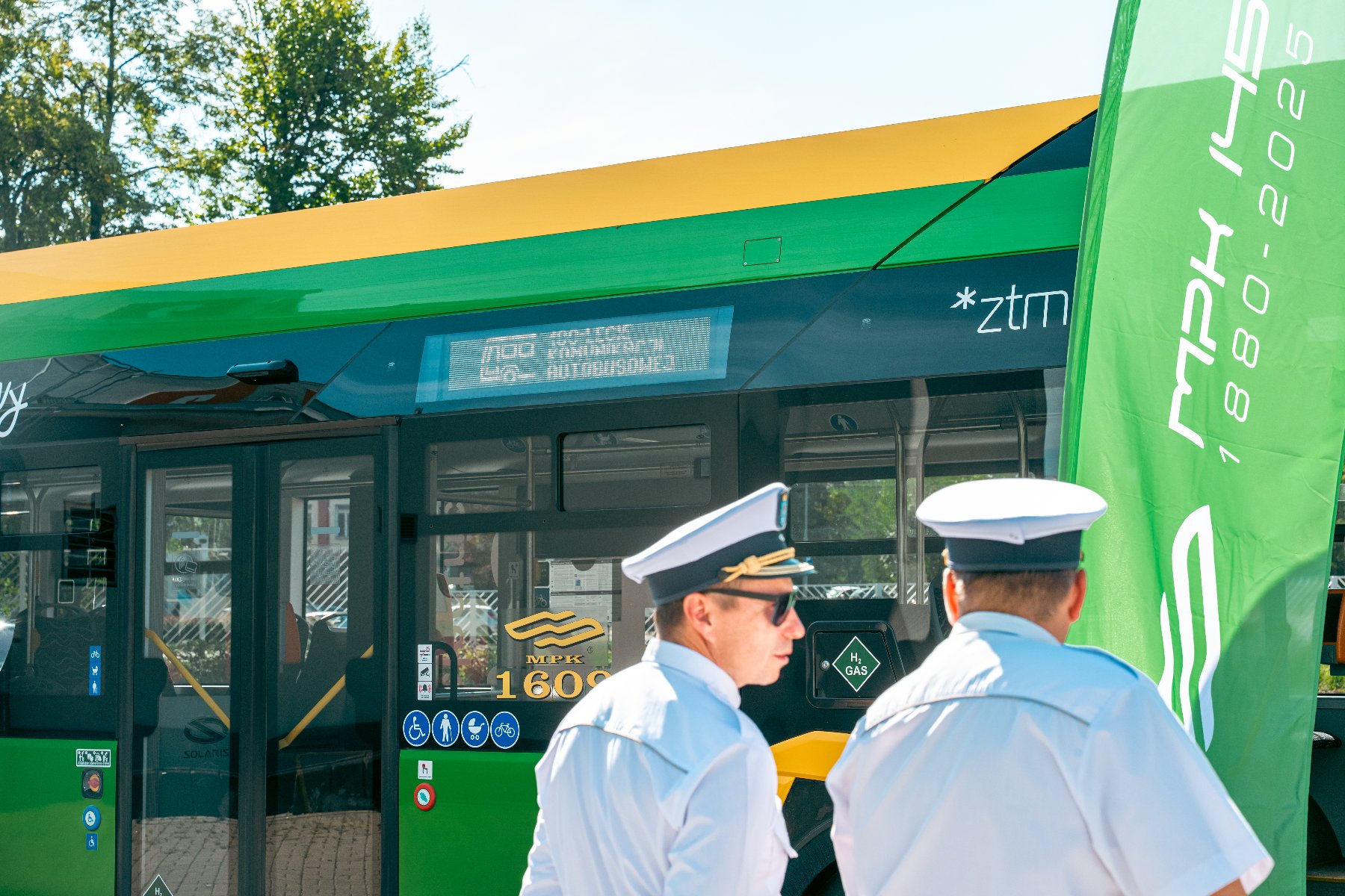 Na zdjęciu dwóch pracowników MPK stoi przed autobusem - grafika artykułu