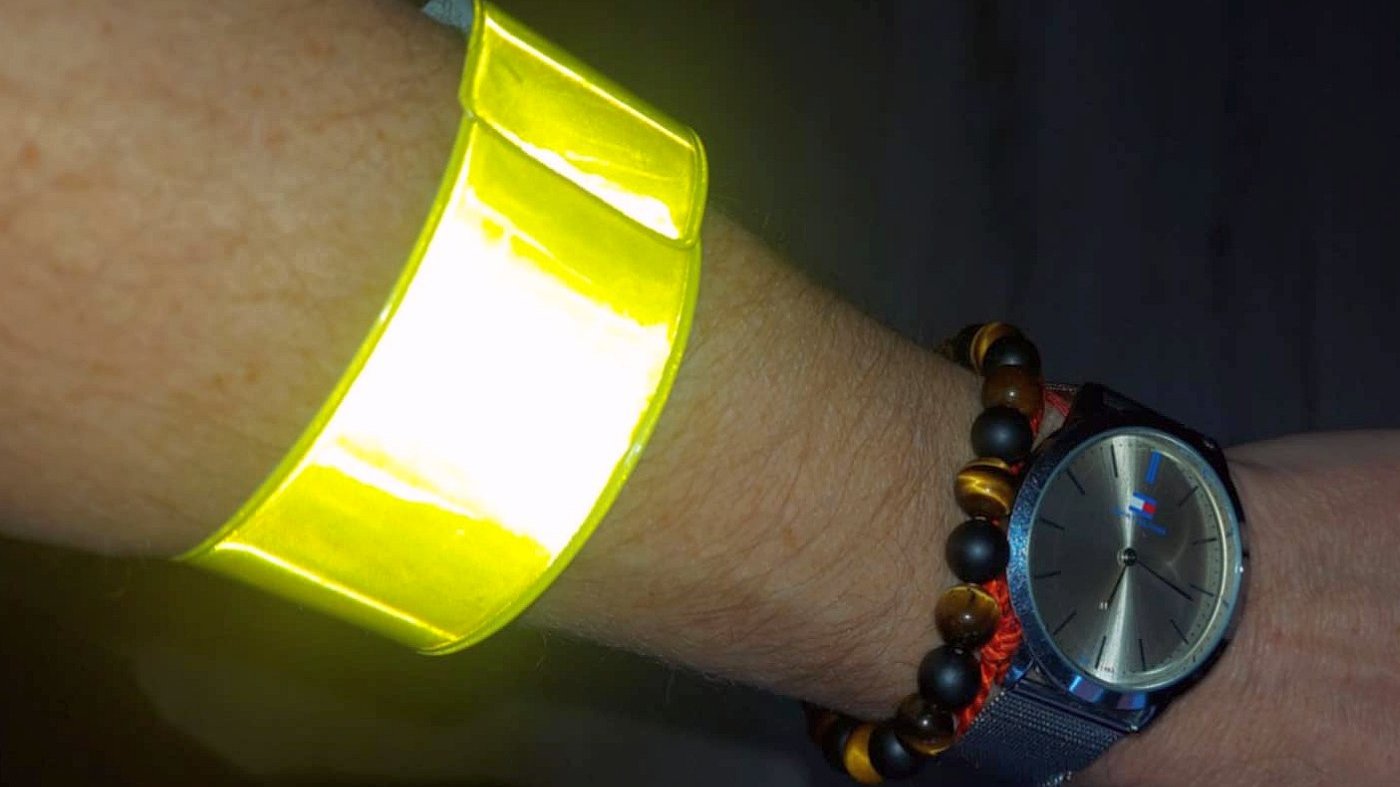 strażniczka demonstruje skuteczność odblasku opaski niezbędnej pieszym po zmroku