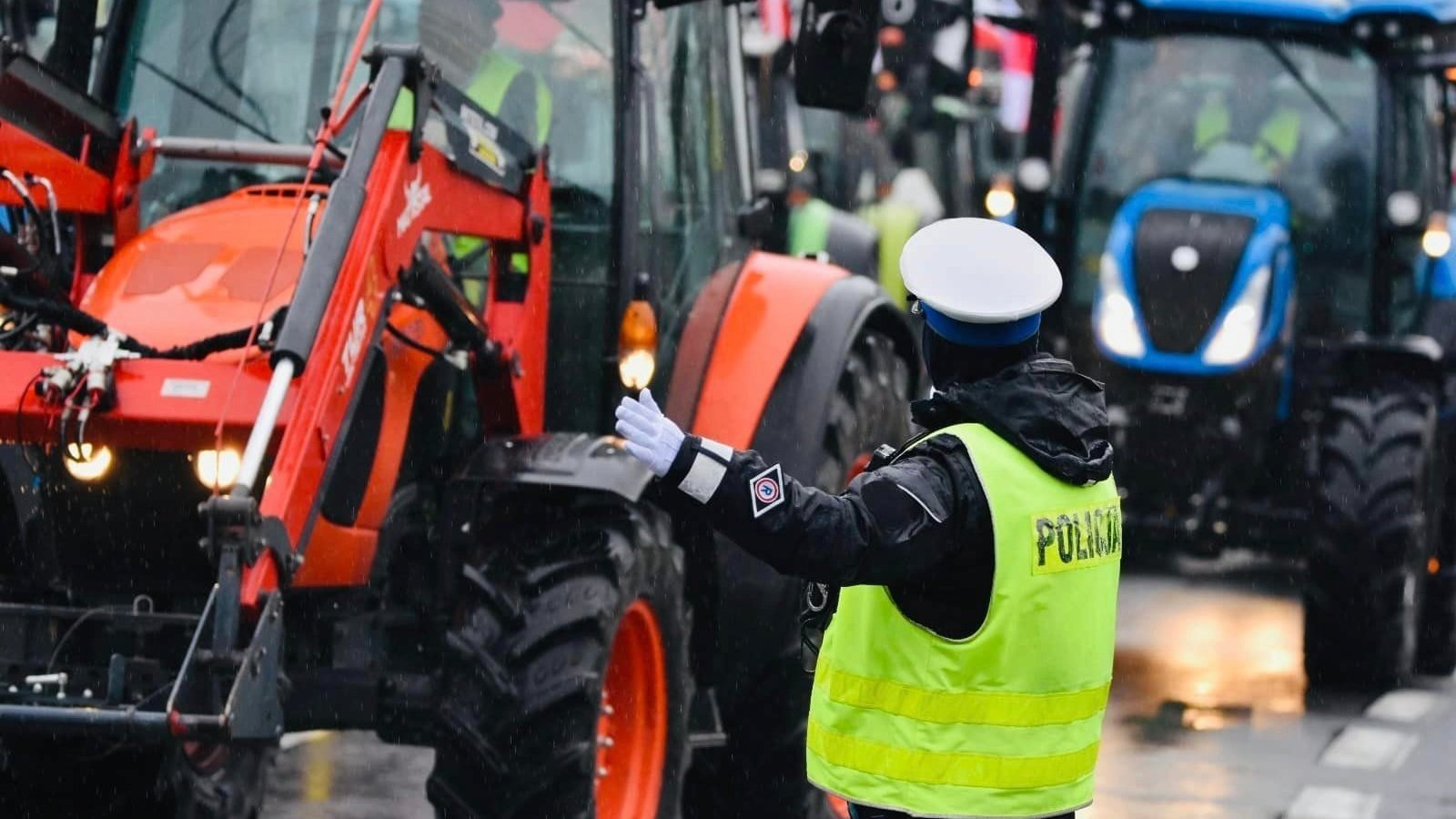 Na czwartek, 10 kwietnia, rolnicy zaplanowali kolejny protest w centrum Poznania fot. Wielkopolska Policja Policjantka w żółtej kamizelce sterująca ruchem ciągników podczas protestu rolników