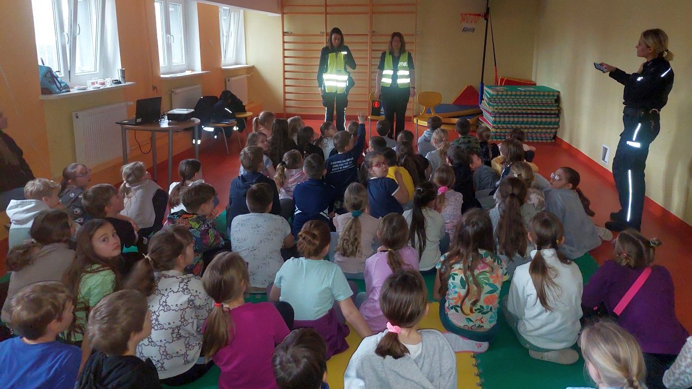 funkcjonariuszki demonstrują "działanie" odblasków na kamizelkach i policyjnym umundurowaniu