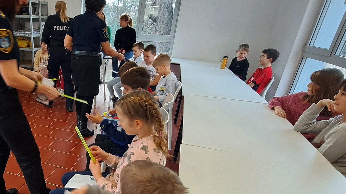 funkcjonariuszki przekazują półkolonistom odblaskowe opaski