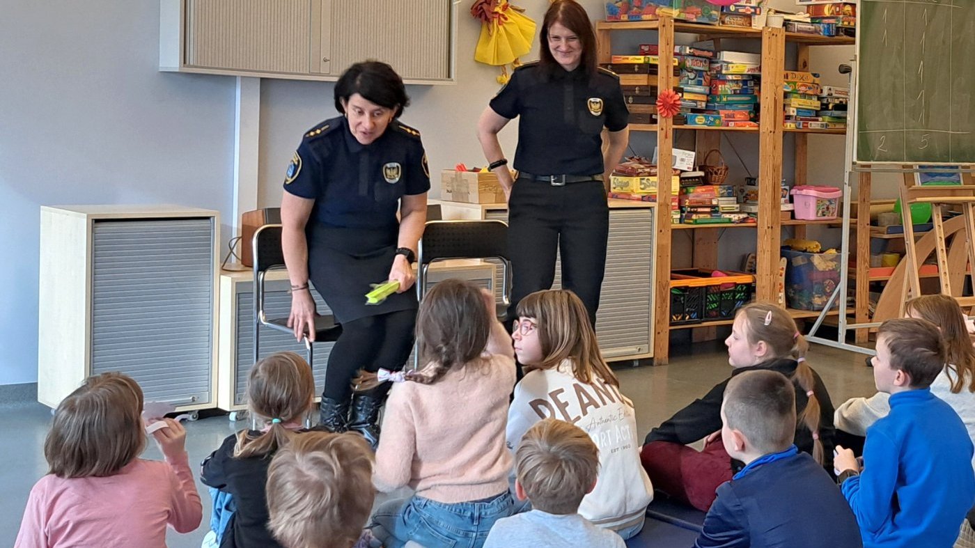 dziewczynka rozmawia ze strażniczką o stosowaniu odblasków na drodze