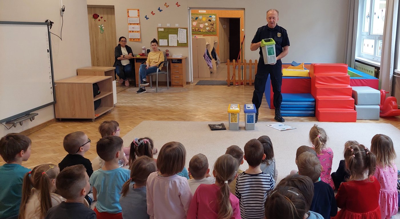 strażnik przedstawia pojemniki do segregacji odpadów