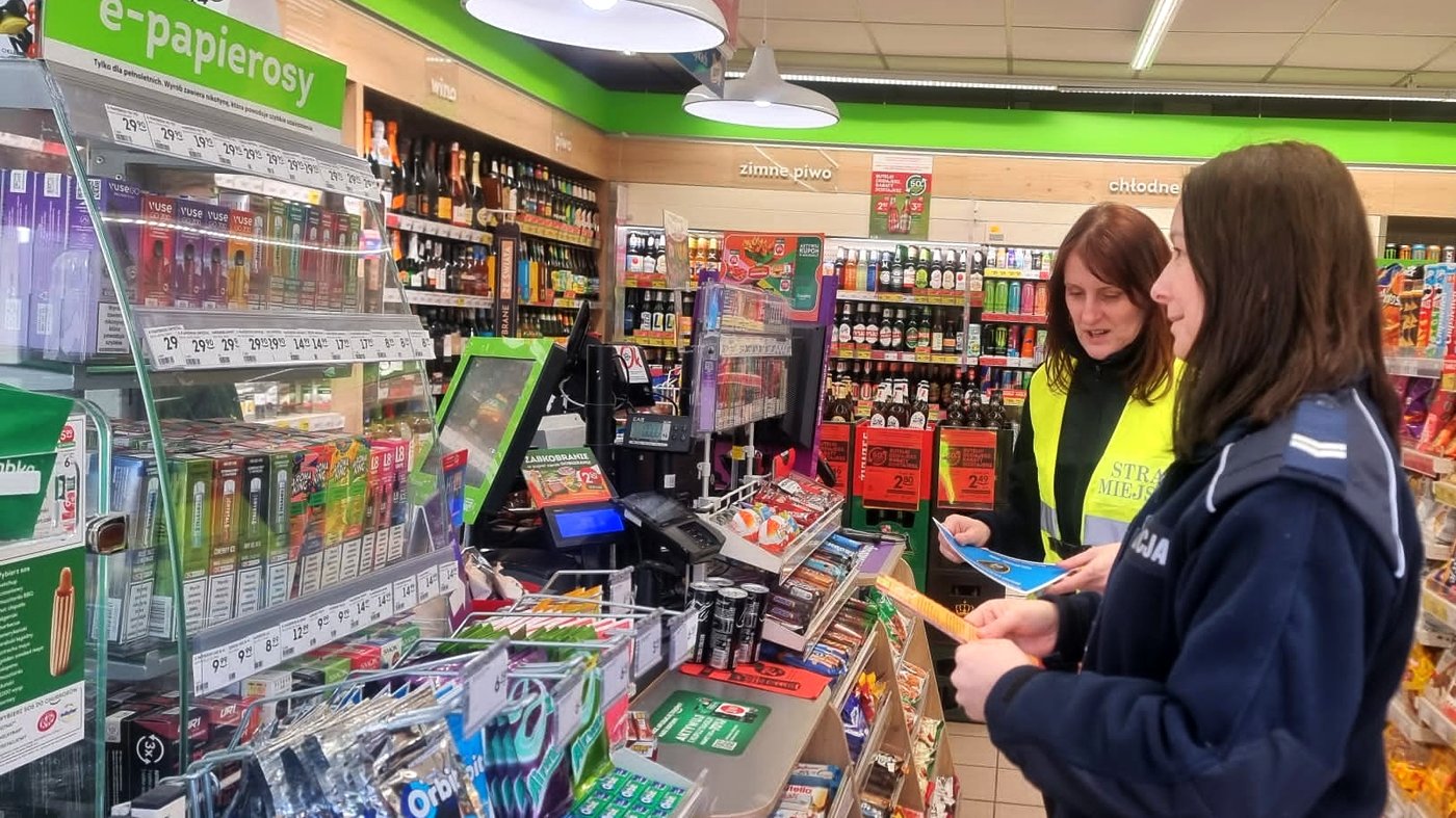 funkcjonariuszki rozmawiają ze sprzedawczynią i przekażą materiały informacyjne