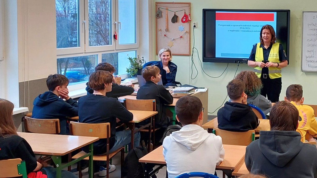 strażniczka omawia przepisy dotyczące nieletnich, w tle slajd prezentacji na ekranie