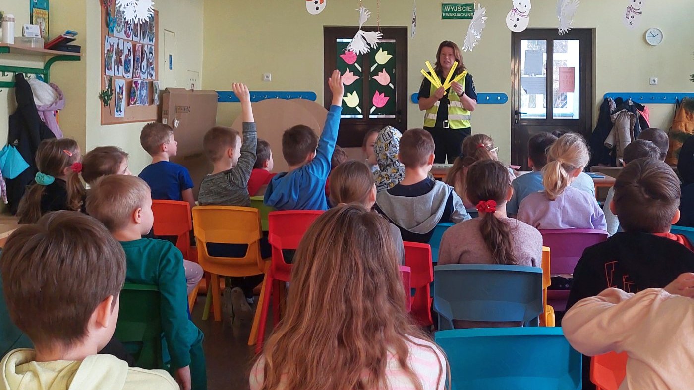strażniczka rozmawia z uczniami o zasadności stosowania odblasków
