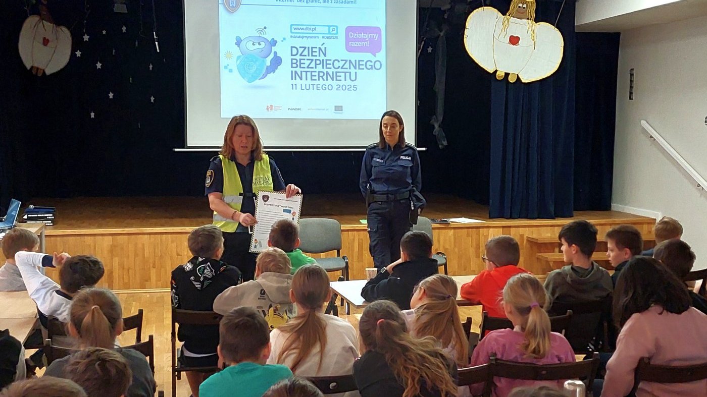 strazniczka z pomocą planszy zapoznaje uczniów z zsasadami bezpiecznego korzystania z sieci