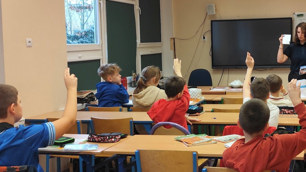 strażniczka prezentuje kieszonkowy kodeks rowerzysty