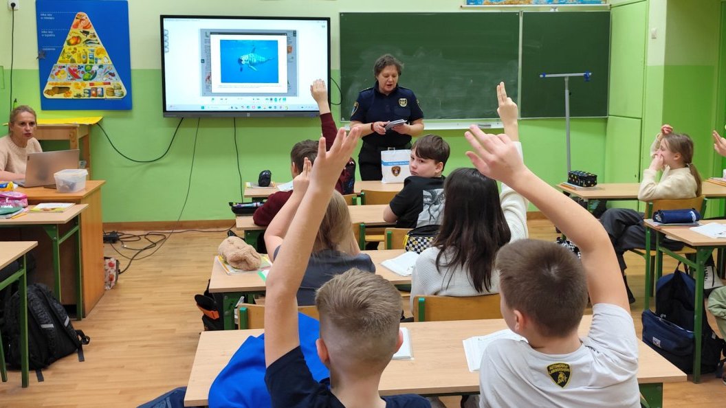 strażniczka prezentuje kieszonkowy kodeks rowerzysty