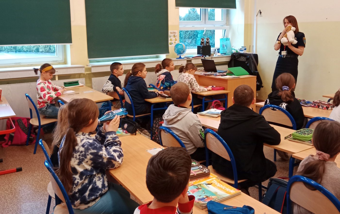 strażniczka rozmawia z uczniami o zachowaniach psa