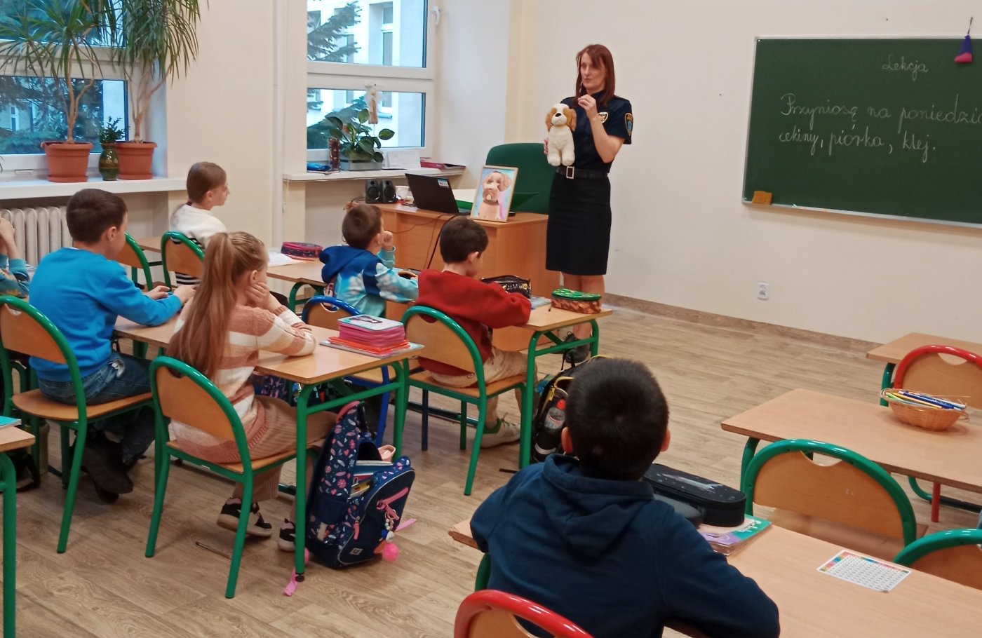 strażniczka rozmawia z uczniami o zachowaniach psa