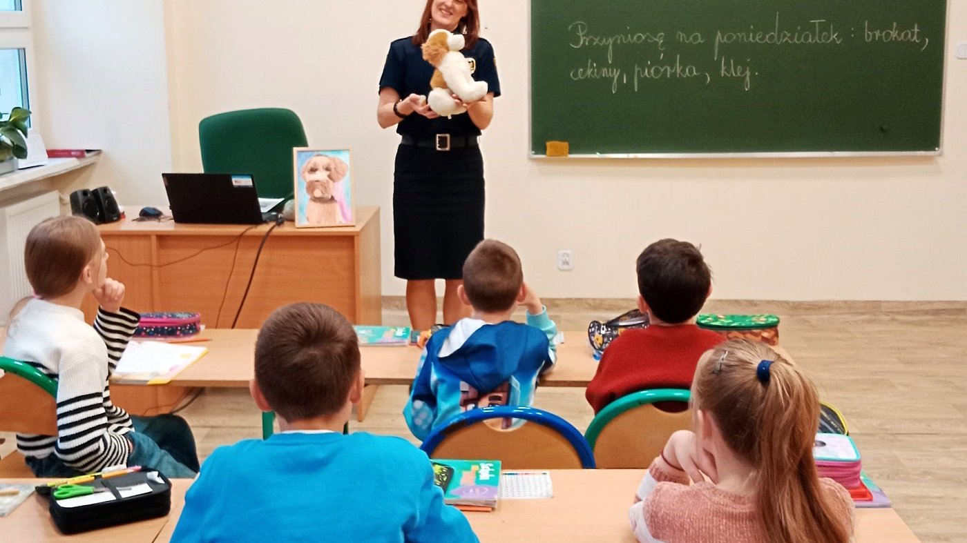 strażniczka rozmawia z uczniami o zachowaniach psa
