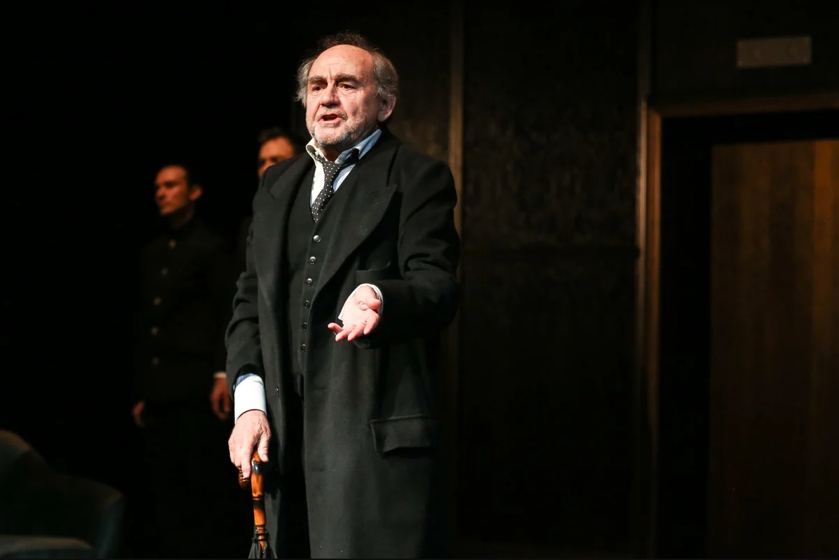 zdjęcie przedstawia aktora Jana Peszka na scenie podczas występu w spektaklu - grafika artykułu