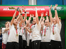 Akademickie Mistrzostwa Polski w futsalu, fot. AZS - zawodniczki AZS UAM Poznań cieszą sięw białych koszulkach, z medalami na szyi oraz pucharem w ręku jednej zawodniczek