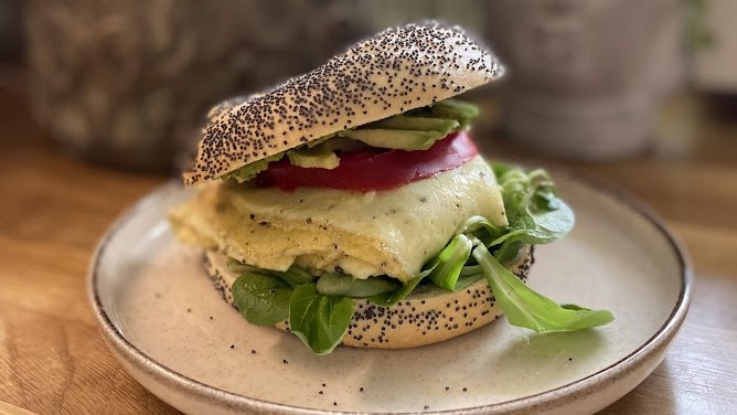 Bajgiel z omletem, sałatą, pomidorem i awokado.