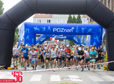 Bieg Czerwca '56 2025, fot. Tomasz Szwajkowski - duża grupa osób startuje w biegu na tle budynków oraz terenów zielonych