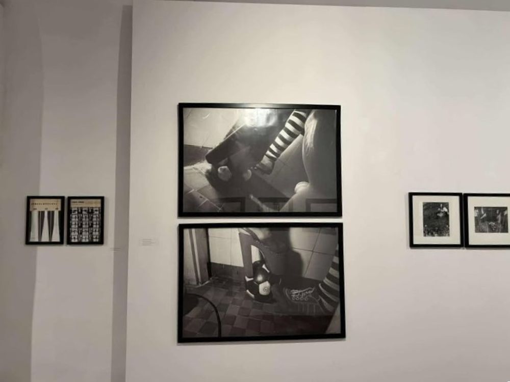 Czarno-białe fotografie na białej ścianie galerii.