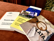 "Cztery książki ułożone na brązowej powierzchni. Na okładkach widoczne są tytuły i autorzy książek: "Maszyny afektywne" autorstwa Moniki Glosowitz; "Wędrowny Zakład Fotograficzny" autorstwa Agnieszki Pajączkowskiej; "Wędrowny Zakład Fotograficzny" autorstwa Agnieszki Pajączkowskiej oraz "Koniec lata" autorstwa Joanny Żabnickiej.