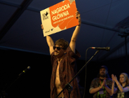 Dawid Tysowski podnoszący do góry tablicę z informacją o wygraniu Go On Stage Festival