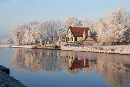 dom nad wodą w zimowej panoramie
