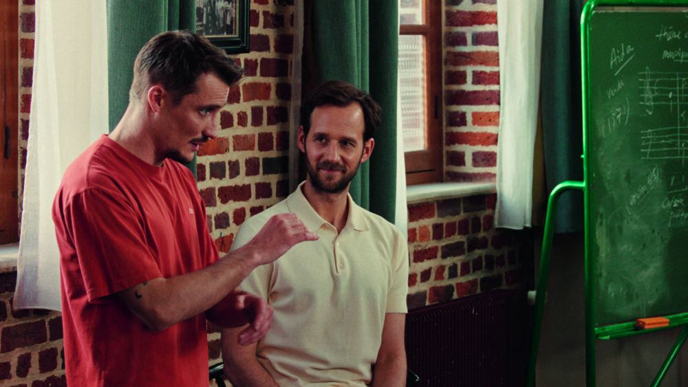 Dwaj mężczyźni rozmawiają w pokoju.