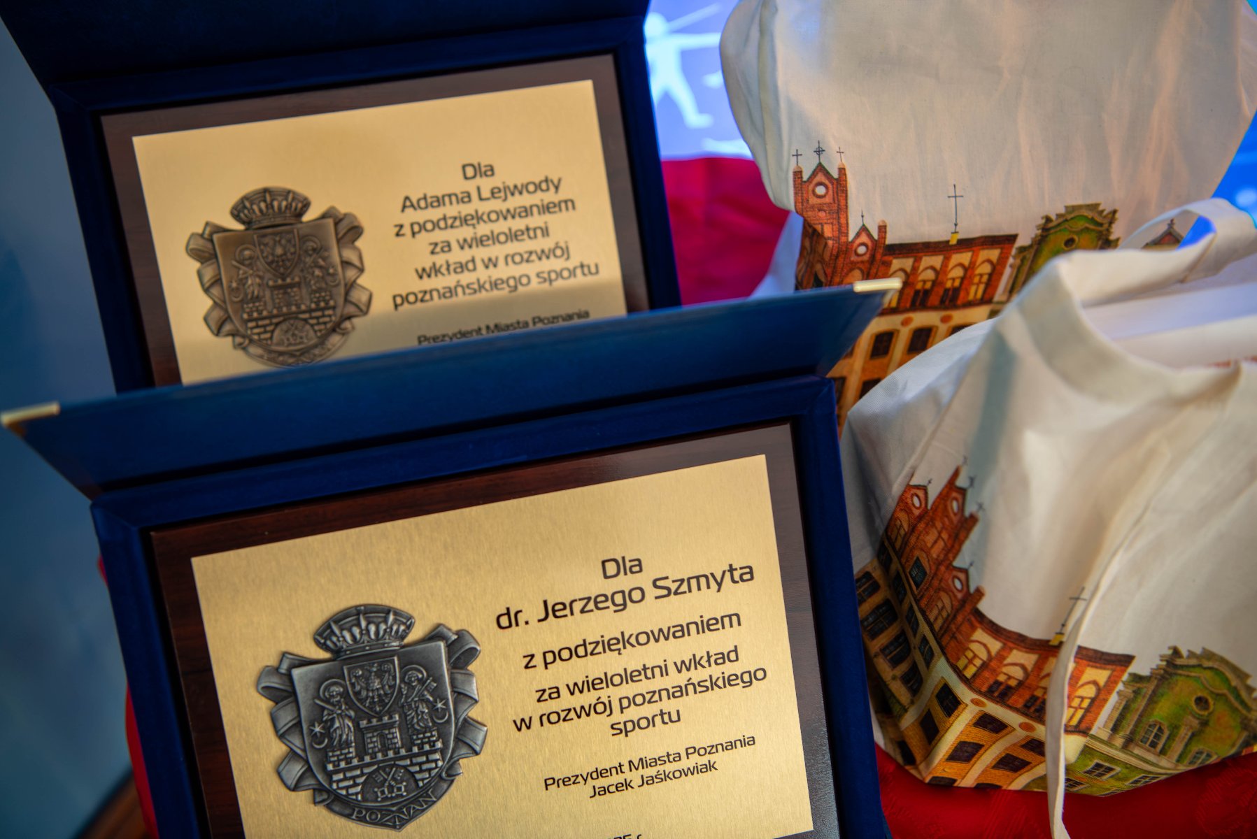 Dwie tabliczki i dwie torby. Tabliczki to nagrody dla osób za wkład w rozwój poznańskiego sportu.