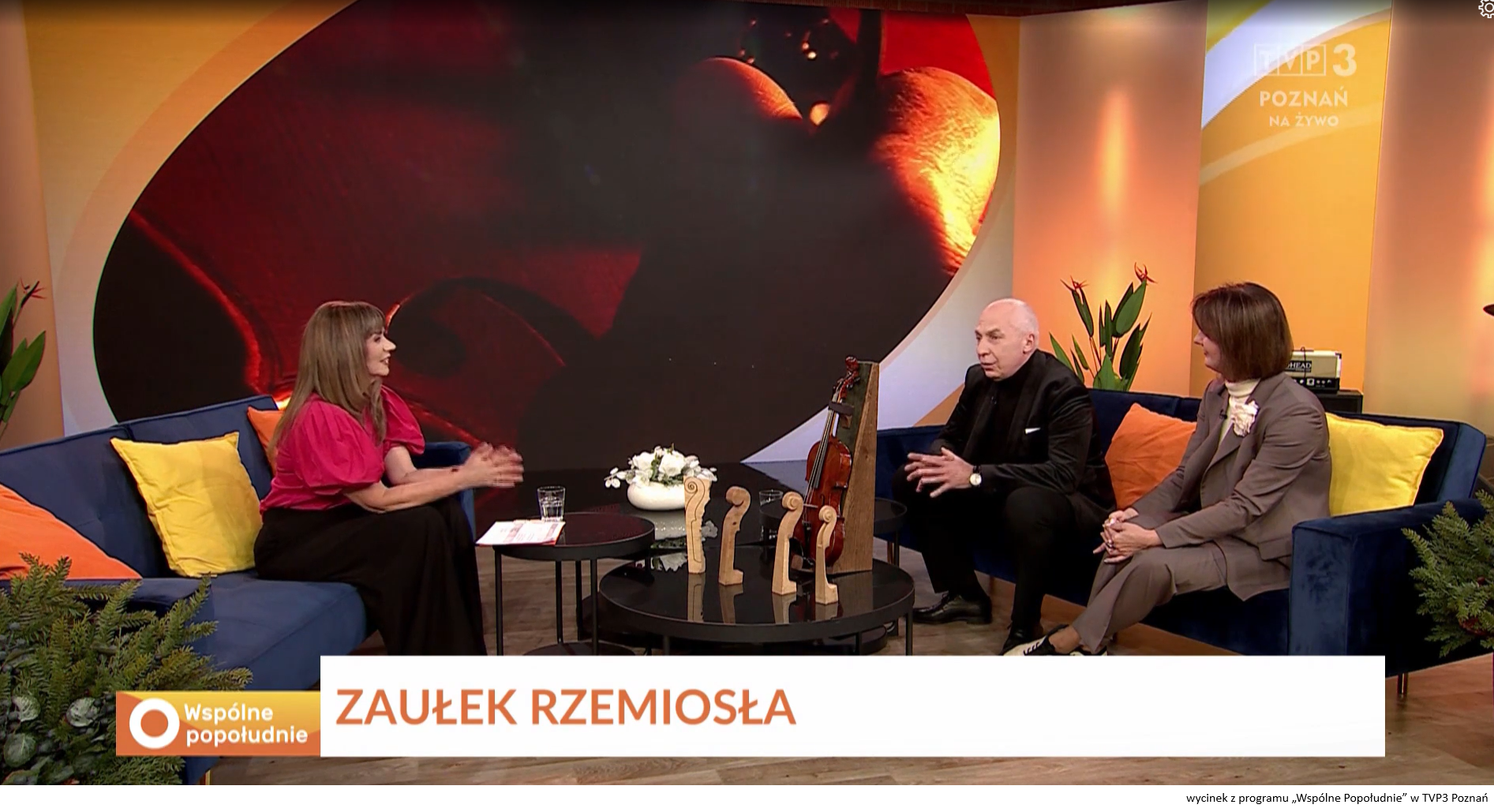 Dwoje ludzi siedzi na kanapie w studiu telewizyjnym i udziela wywiadu