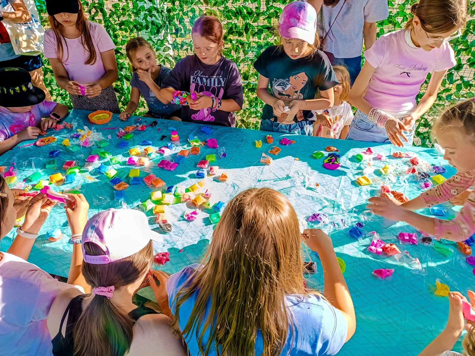 Dzieci przy stole wykonują prace z plasteliny.