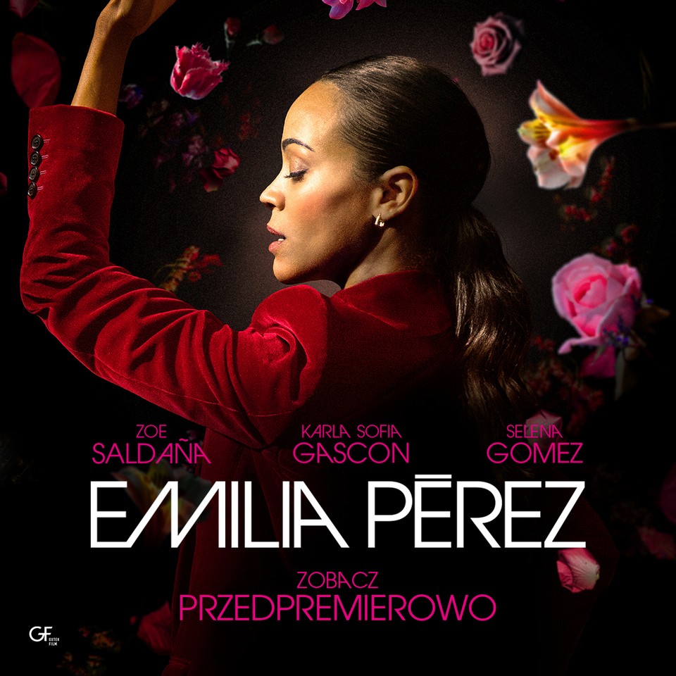 Grafika z czarnym tłem, na której znajduje się zdjęcie kobiety wykonującej taneczną pozycję z uniesioną dłonią. Wokół niej różowe, pomarańczowe i białe kwiaty. Poniżej napis EMILIA PEREZ.