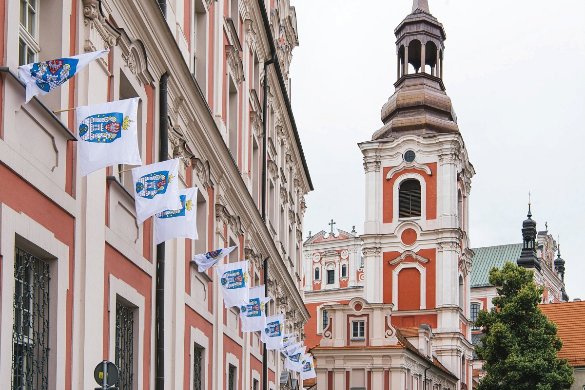 Flagi Miasta Poznania z herbem zawieszone na fasadzie gmachu Urzędu Miasta - więcej w artykule
