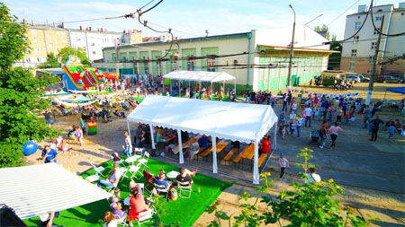 Ławki pod namiotami Dookoła chodzą lub siedzą dzieci i dorośli.