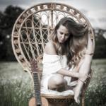 Na wiklinowym fotelu siedzi Ola Jas.