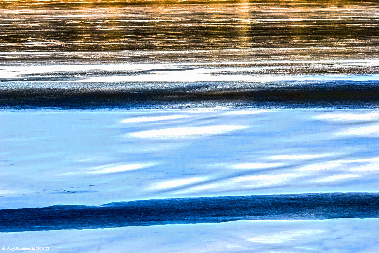 Odbicie zachodzącego słońca na tafli wody jeziora.