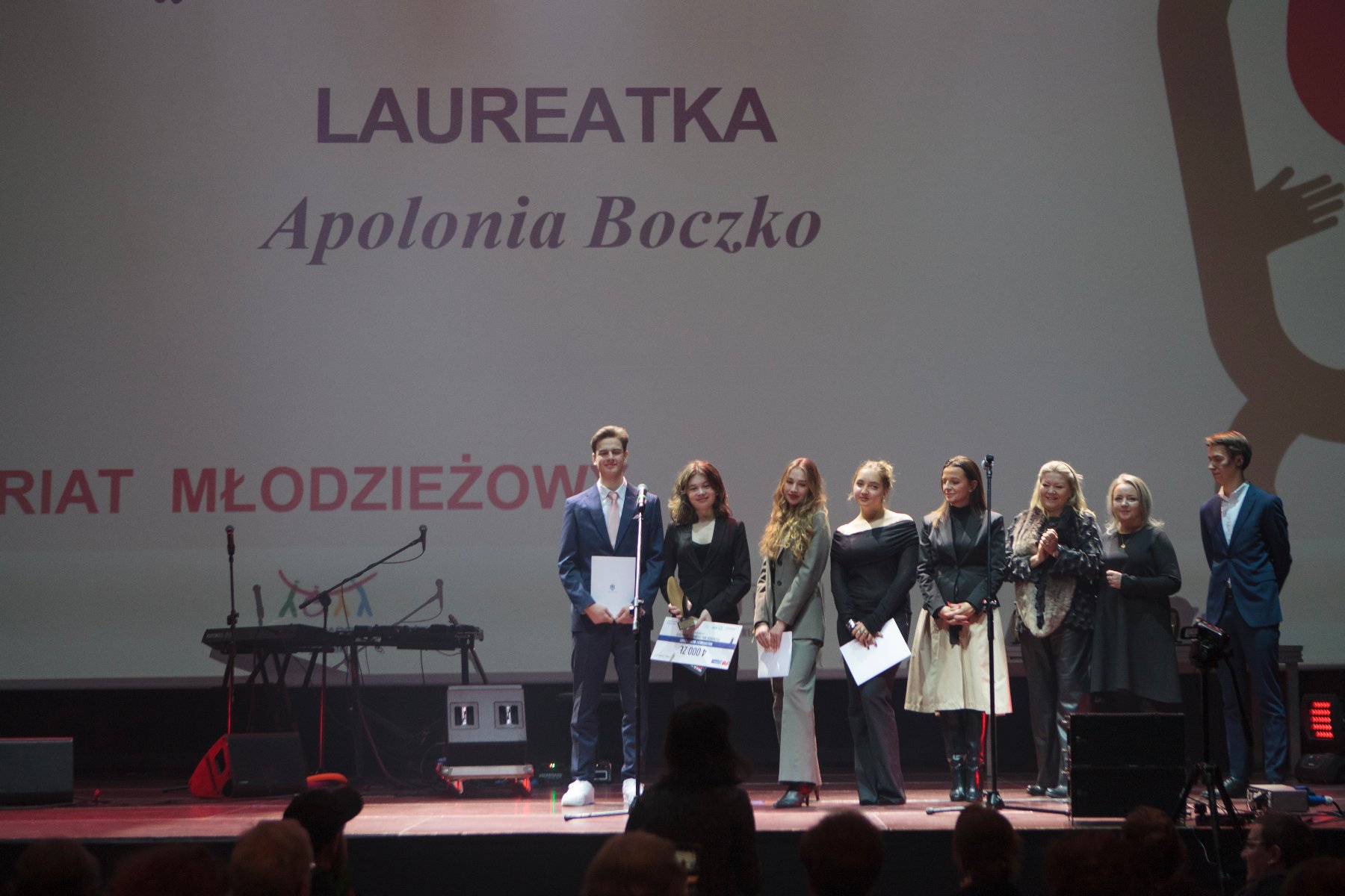 Na zdjęciu znajduje się grupa osób stojąca na scenie podczas gali konkursu.