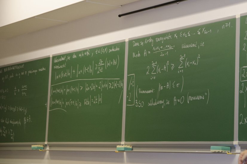 Grafika przedstawia tablicę szkolną z zapisanymi wzorami z matematyki