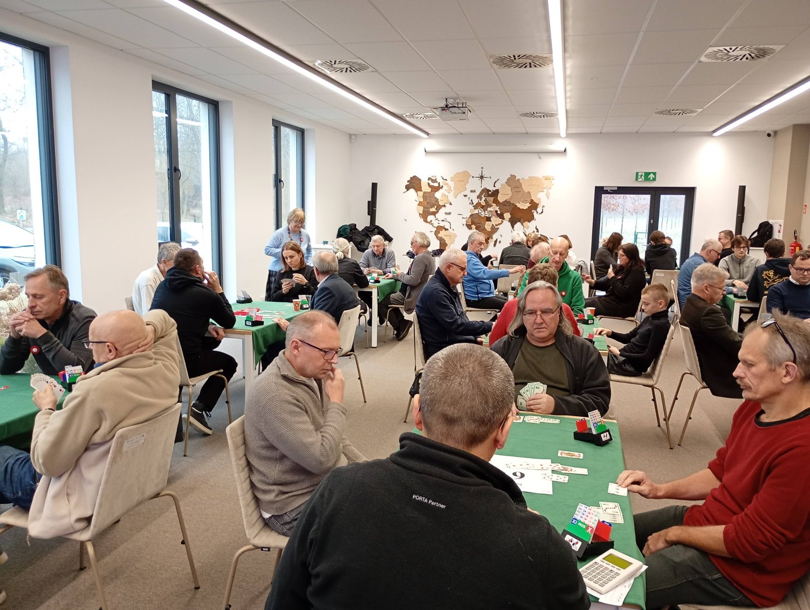 III Powstańczy Open "27 Grudnia - Pamiętamy!" - w sali przy kilkunastach stolikach siedzą brydżyści i grają w karty
