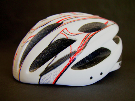 Kask rowerowy na ciemnym tle.