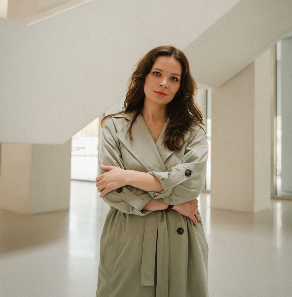 Kobieta w beżowym trenczu i rozpuszczonych włosach.