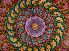 Kolorowa mandala namalowana farbami, kolory: czerwony, zielony, żółty, różowy i fioletowy, wzór kwiatowy