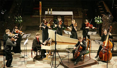 Koncert. Muzycy graja na fortepianie i istrumentach smyczkowych.