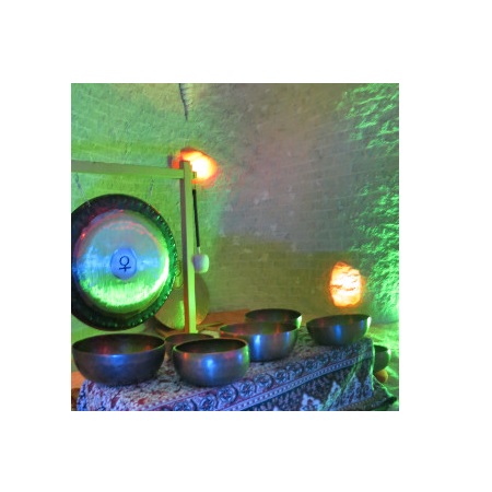 Misy na stoliku przykrytym tkaniną. Za misami gong na stojaku.