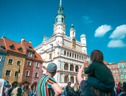 Ludzie na Starym Rynku obserwujący Ratusz i koziołki