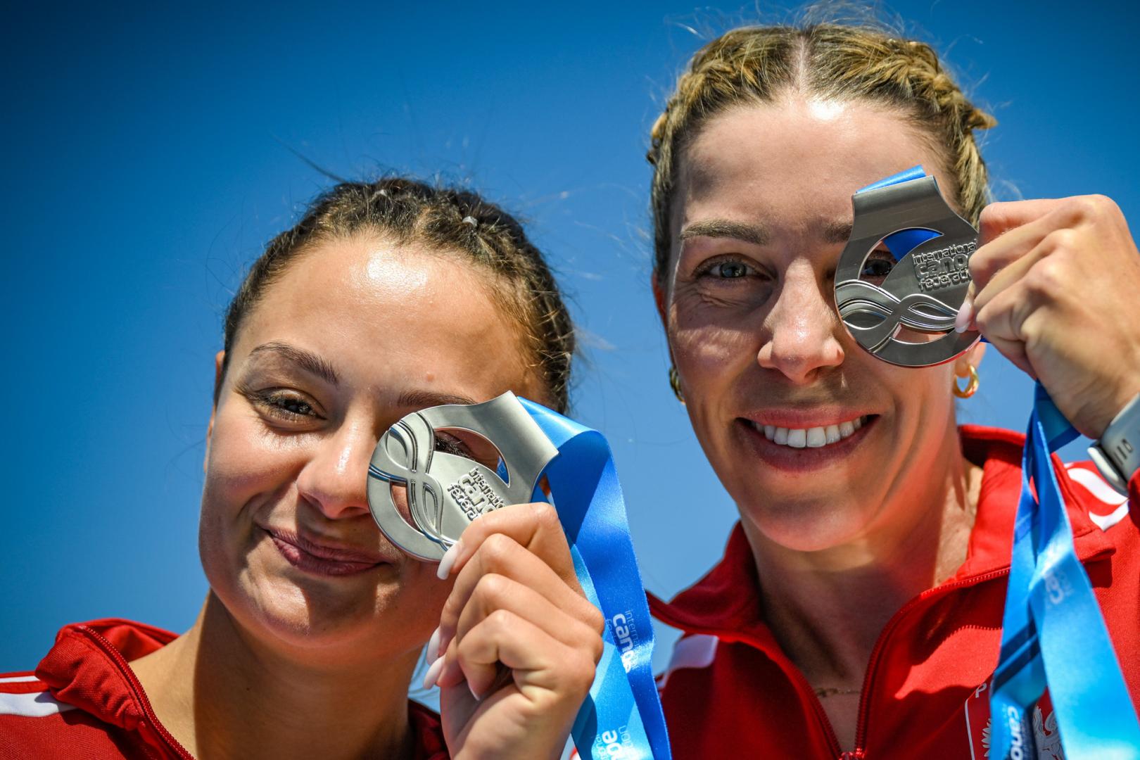 Martyna Klatt i Anna Puławska z medalami na PŚ w kajakarstwie - 2 uśmiechnięte kobiety trzymają w rękach medale, które trzymają na wysokości oczu
