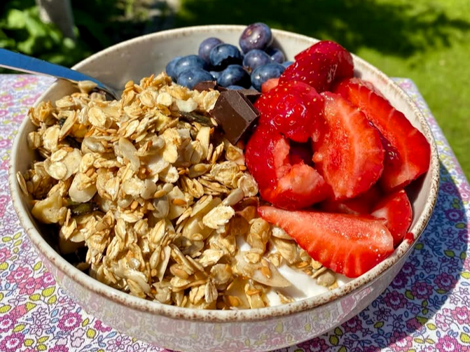 Miseczka z bowlem śniadaniowym ze skyrem naturalnym, domową granolą, sezonowymi owocami i nutą gorzkiej czekolady.