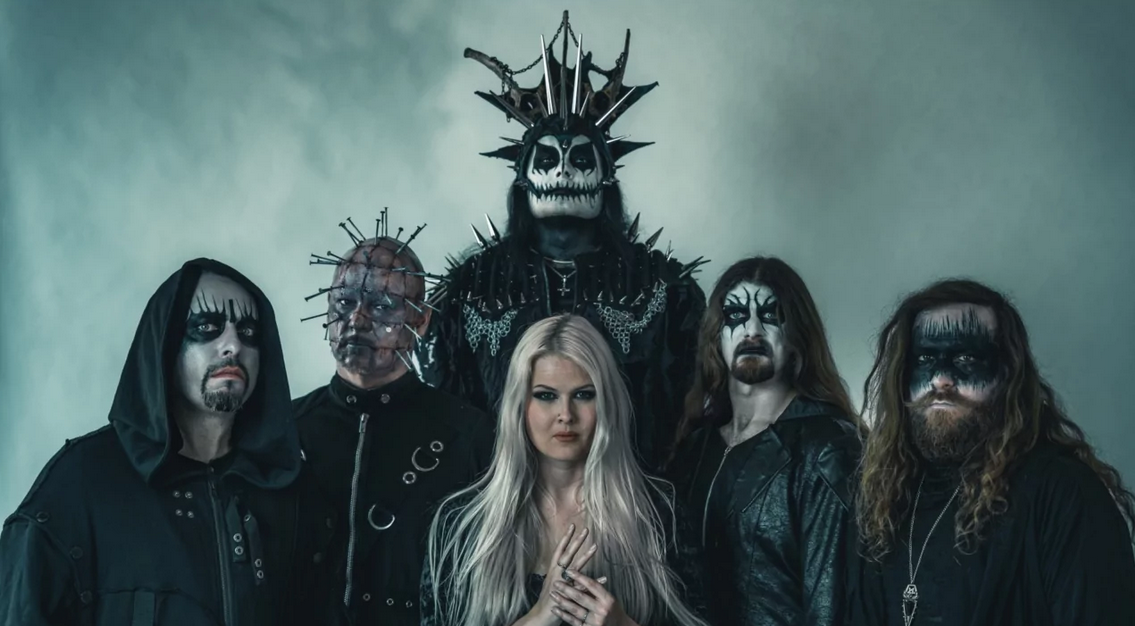 Muzycy pozują w pomieszczeniu, którego ściany wyglądają, jakby skapywała z nich krew. W środku artystycznie umalowany wokalista, ma złożone dłonie.