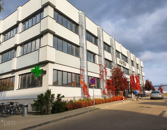 Na zdjęciu budynek POSUM, przed nim widać mężczyznę na rowerze