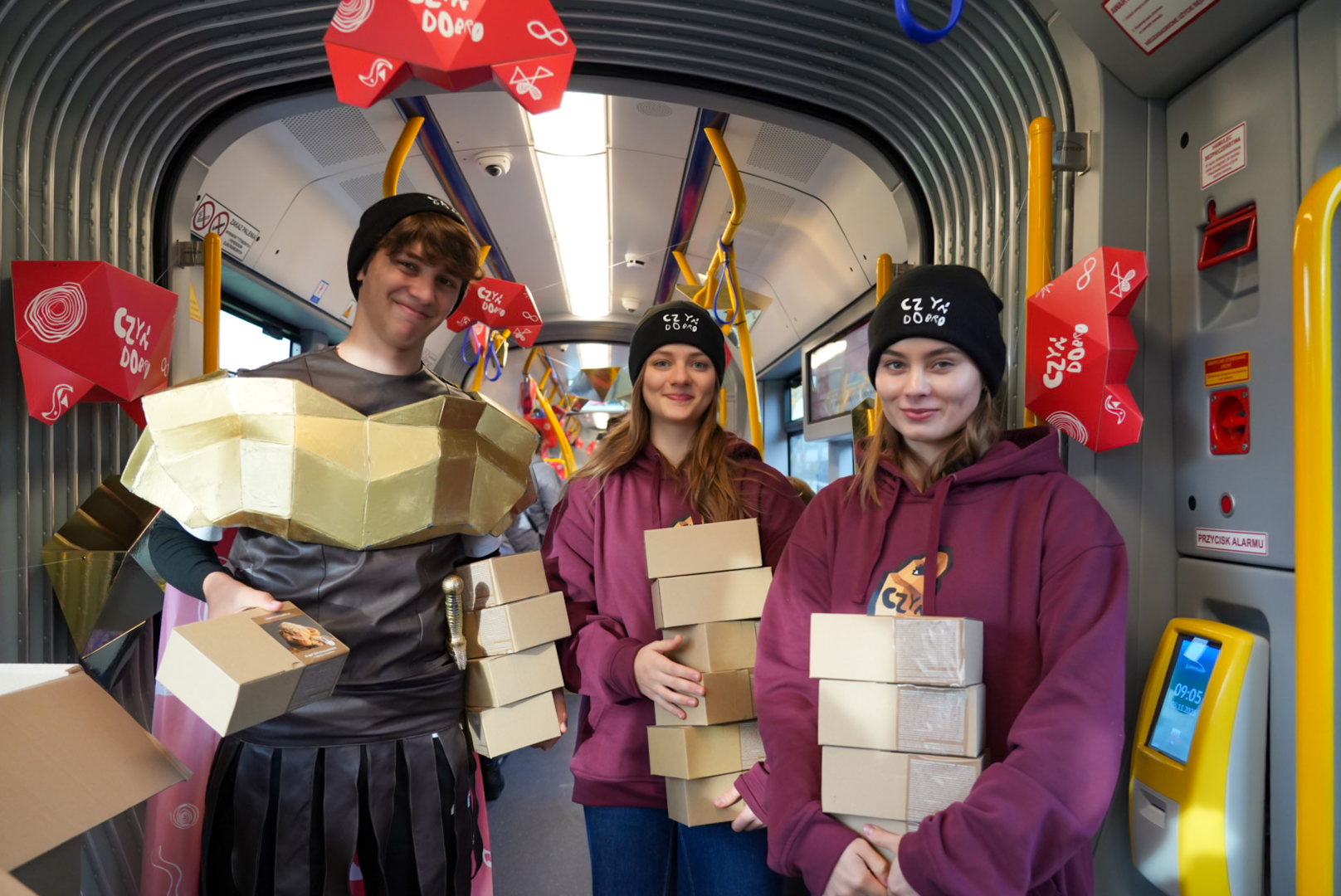 Na zdjęciu dłonie trzymające rogala, w tle poznański Ratusz