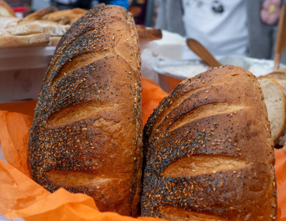 Na zdjęciu dwa chleby leżące na pomarańczowej serwetce